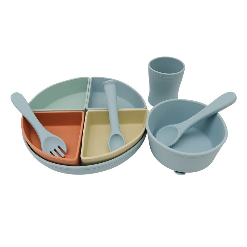 Ergonomic baby silicone spoon and fork displayed inside colourful silicone plate compartments.